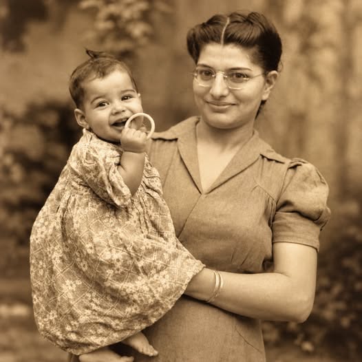 Тази вълнуваща снимка от 1947 г. показва бъдеща музикална икона като дете, спокойно сгушено в ръцете на майка си — десетилетия преди светът да чуе невероятния му глас. 🎶✨ Тогава той е бил просто дете, заобиколено от любящо семейство, далеч от препълнените стадиони, ослепителните светлини и силните песни, които един ден щели да бележат цяла епоха в музиката. 🎤 1 800756453 1870391654370847 6470644784771717034 n